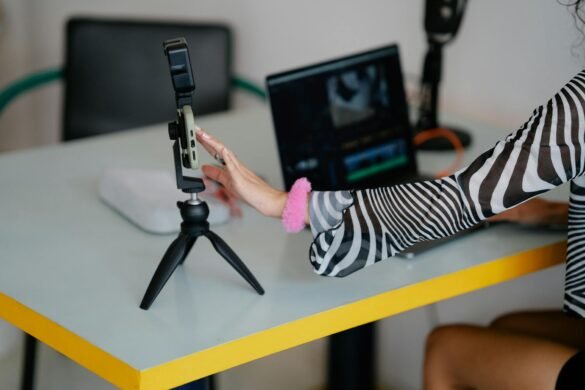 woman using smart phone on tripod and a laptop computer